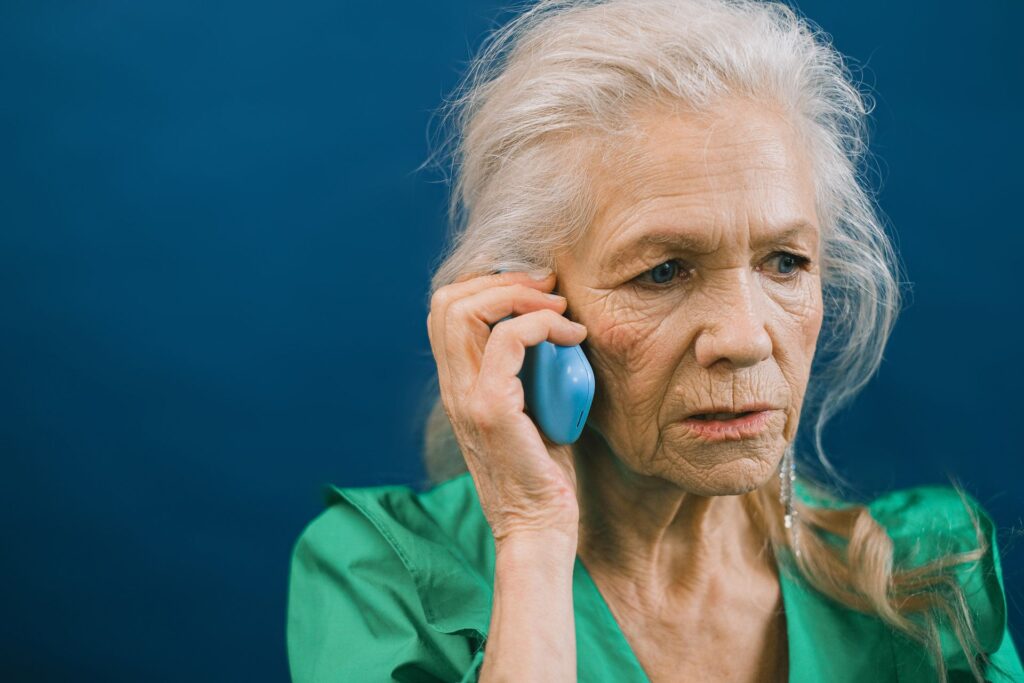 Telefonla konuşan endişeli yaşlı kadın - sesli deepfake dolandırıcılığı