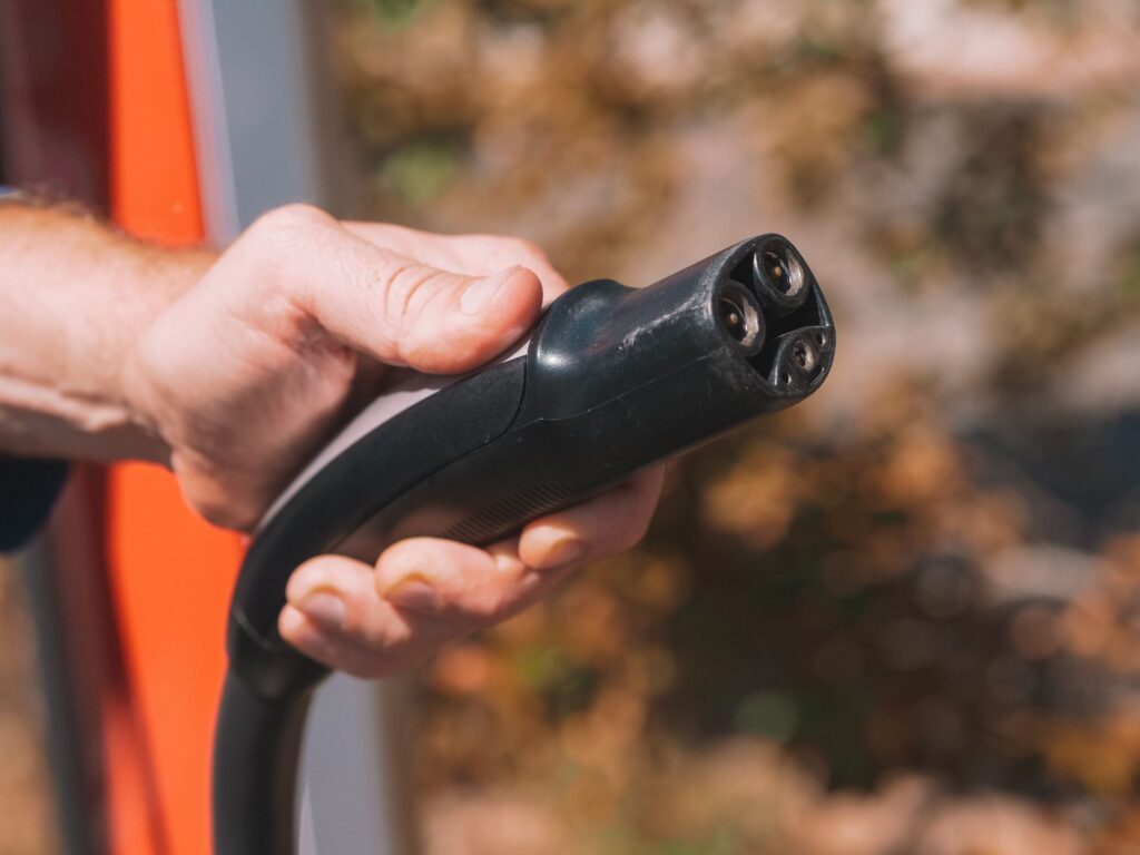 Tik Tak Bilgi - Elinde elektrikli araç hızlı şarj soketi tutan sürücü