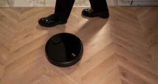 Tik Tak Bilgi - Ahşap zeminde çalışan siyah robot süpürge