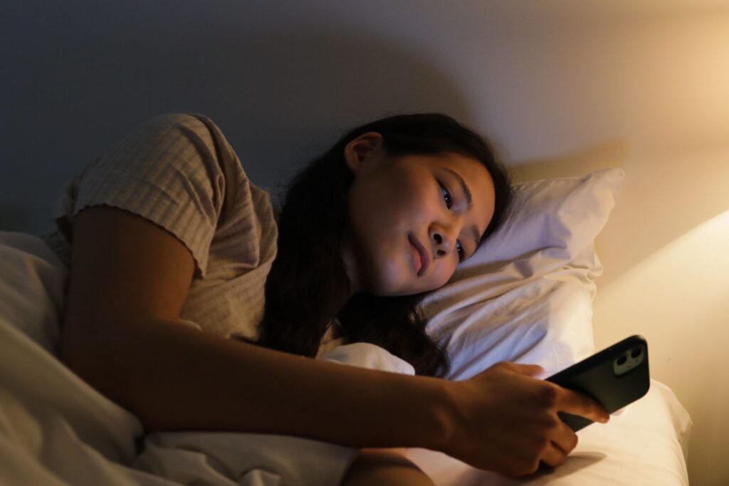 Gece yatakta telefona bakan kadın - ekran ışığının uykuya etkisi